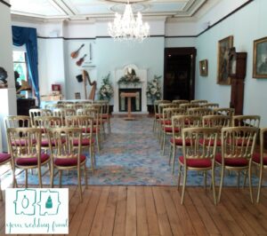 quaint elegant room with rows of gold chairs and red seats