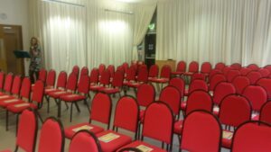 ceremony room with lines of red seated chairs